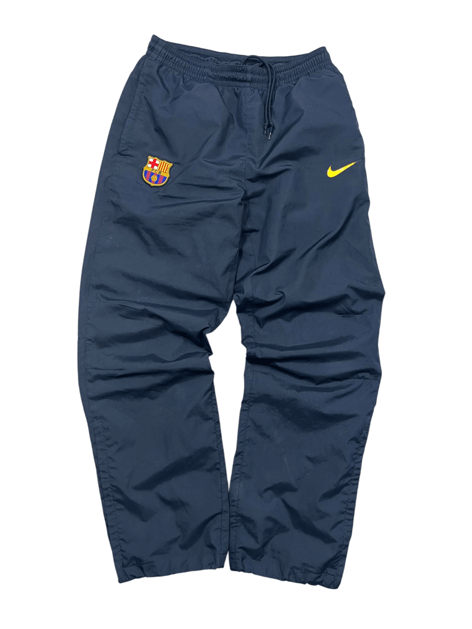 Sötétkék vintage Nike melegítőnadrág Barcelona hímzett logóval, streetwear stílusban.