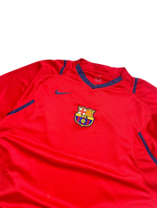 Piros vintage Nike focimez, elől FCB címerrel és kék betétekkel, streetwear stílusban.