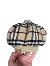 Bézs kockás mintás vintage streetwear sapka kézben, retro stílusban.
