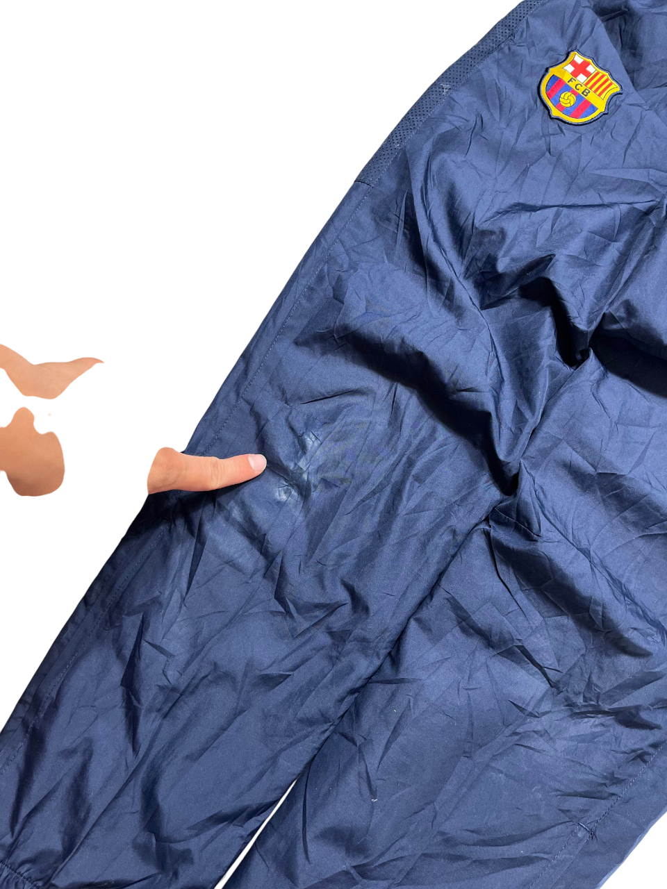 Sötétkék Barcelona logós trackpants, kis sérüléssel az anyagon, streetwear stílusban.