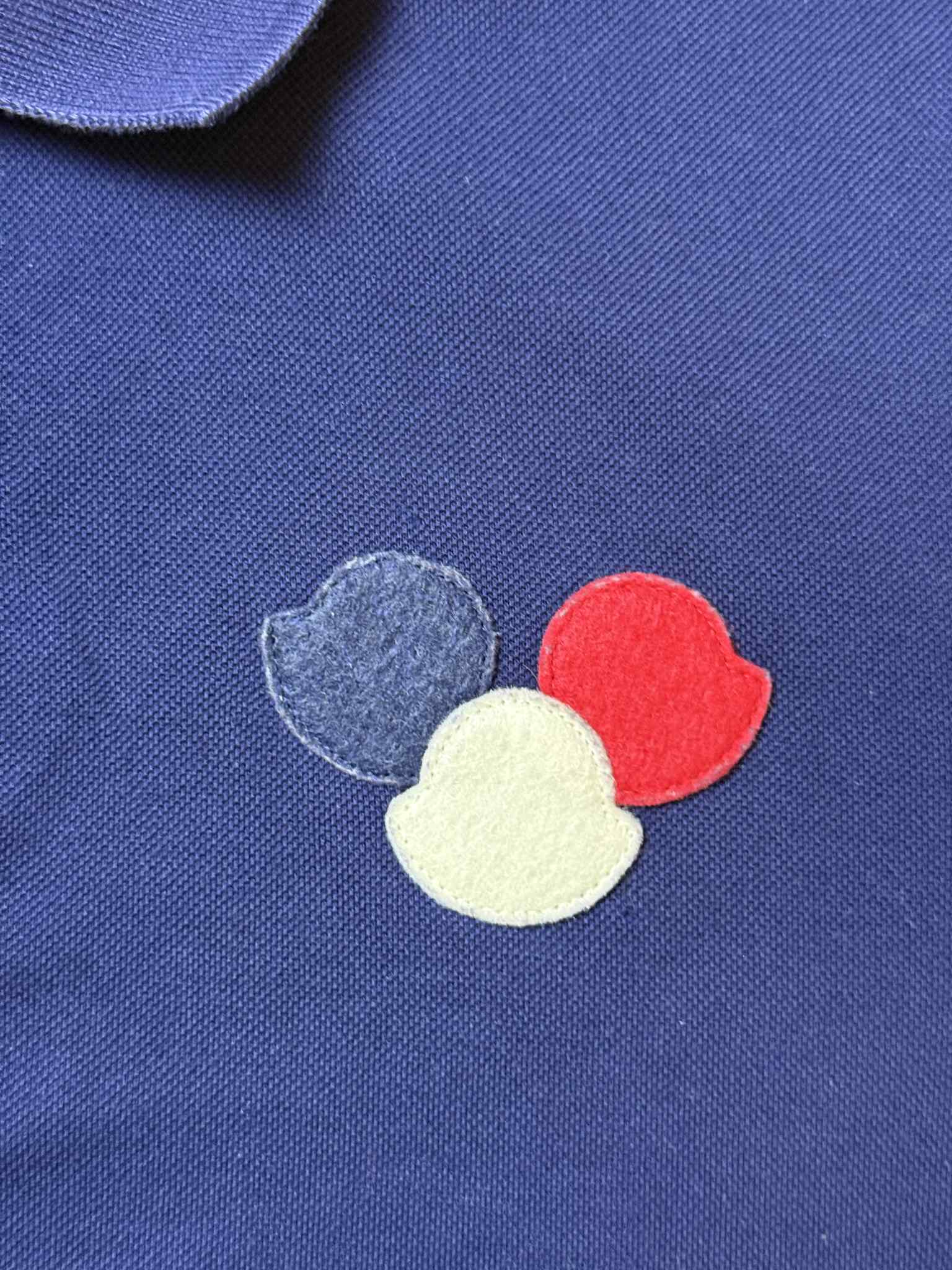 Kék póló, mellrészen háromszínű (kék, piros, fehér) hímzett streetwear embléma