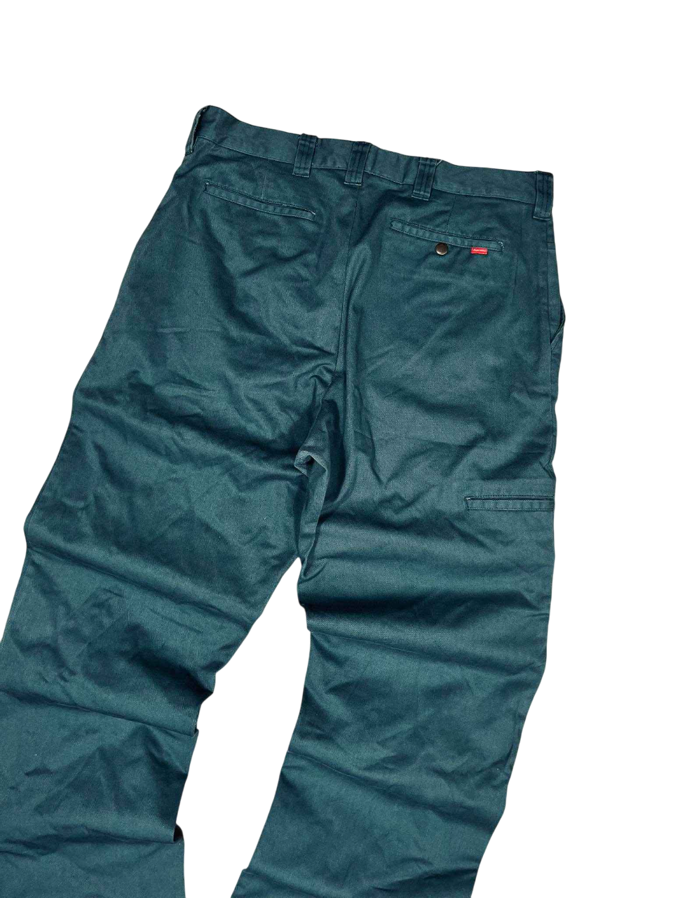Sötétzöld vintage streetwear nadrág, farzsebekkel és övbujtatókkal, fekete háttéren.