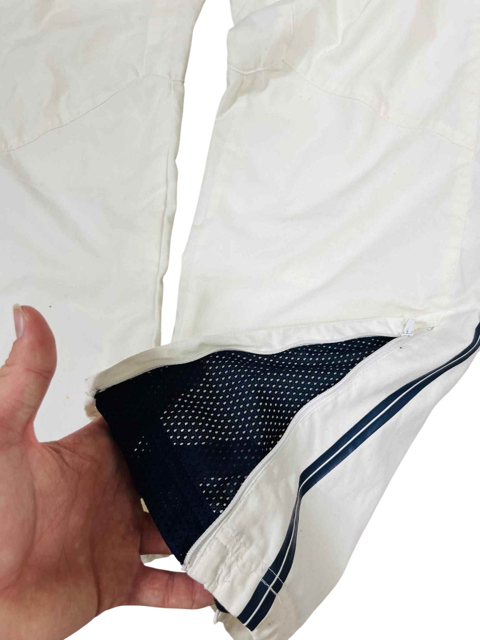 Fehér sportos streetwear nadrág kék csíkkal, hálós béléssel és cipzáros szárvéggel